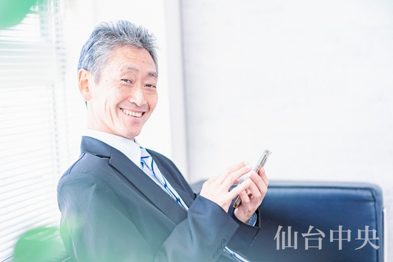 薄毛治療についてスマホで検索する50歳代の男性
