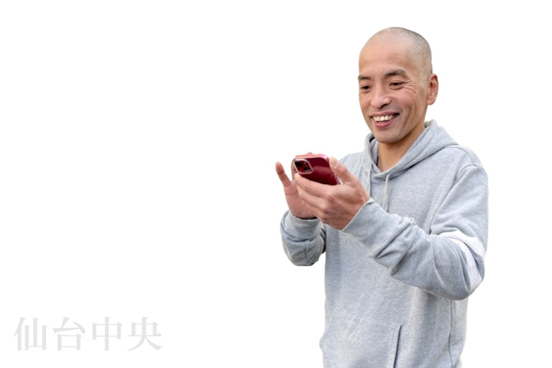 薄毛治療を考えてスマートフォンで検索する男性